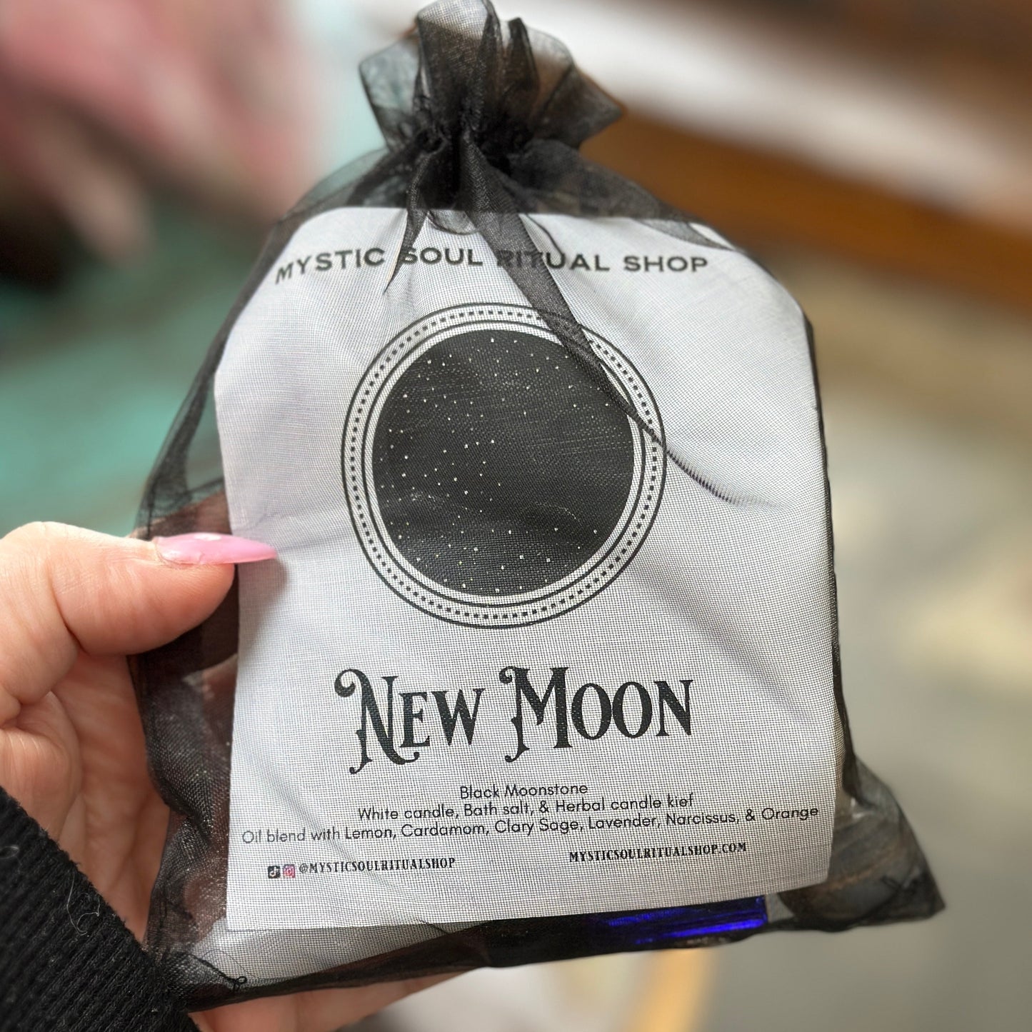 Pouch labeled 'New Moon' from Mystic Soul Ritual Shop held by a hand.