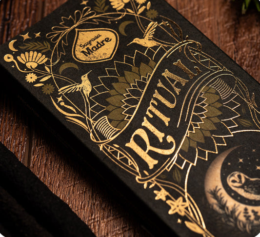Decorative packaging with gold text and illustrations on a dark background