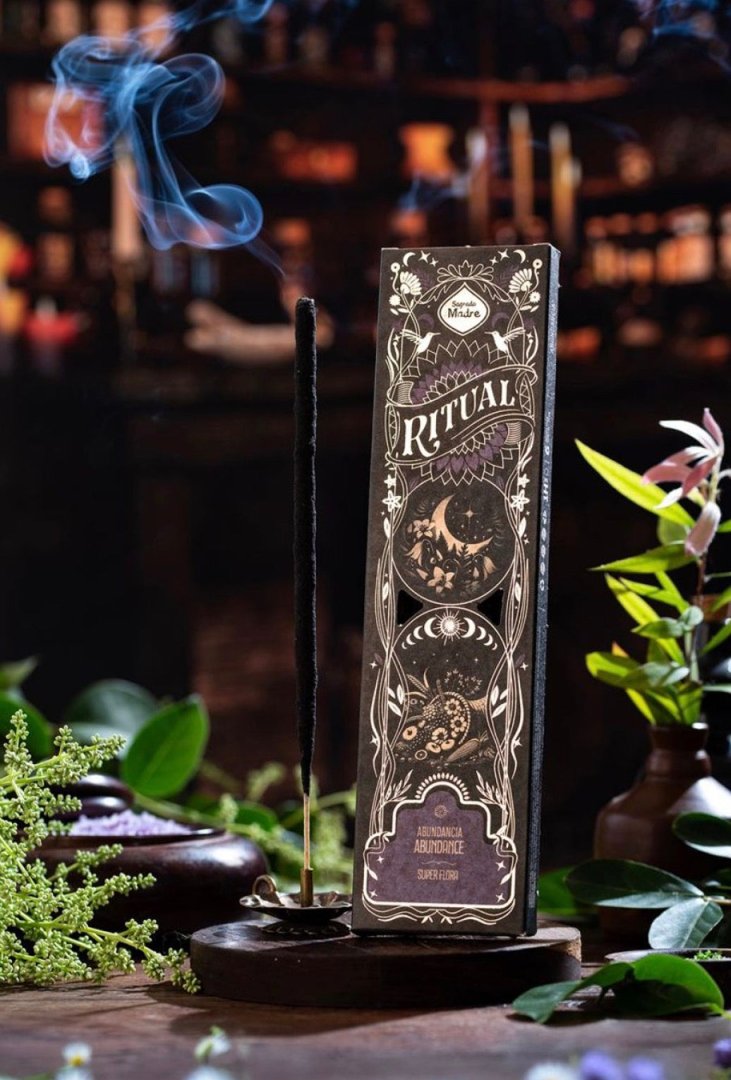 Decorative bottle with 'Ritual' label on a wooden stand with smoke and plants in the background