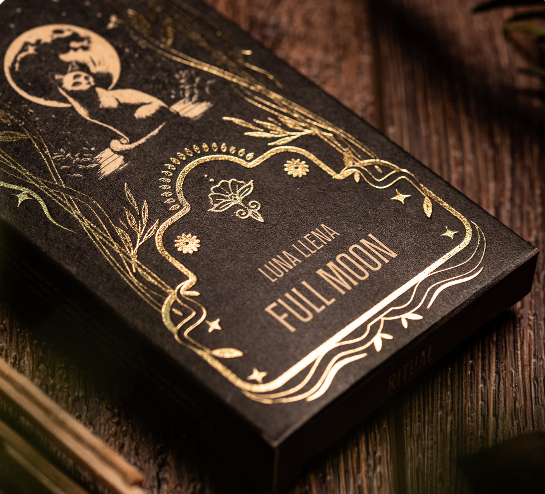 Black book with gold embossed text and design on a wooden surface