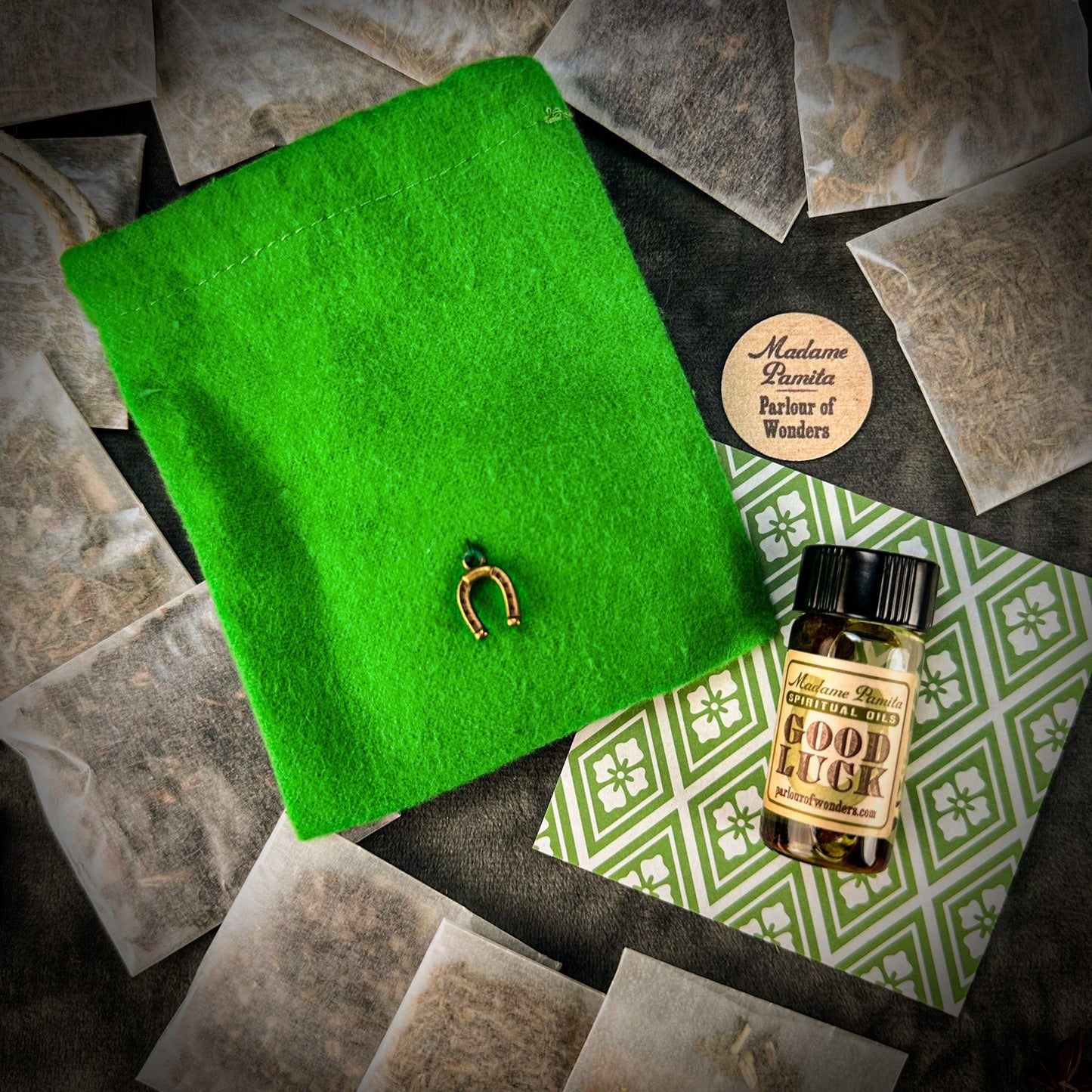 Green book with a gold幸运符 on a surface with tea bags and a bottle labeled 'Good Luck'.