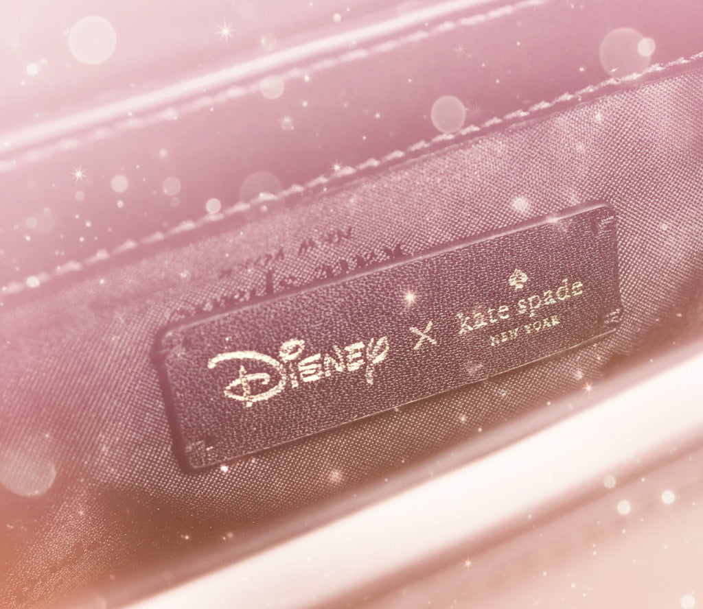 Close-up of a black leather label featuring Disney and Kate Spade logos.