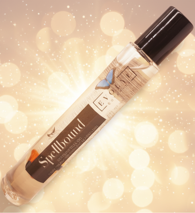 Roll-on bottle with 'Spellbound' label on a blurred lights background
