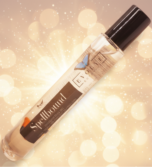 Roll-on bottle with 'Spellbound' label on a blurred lights background