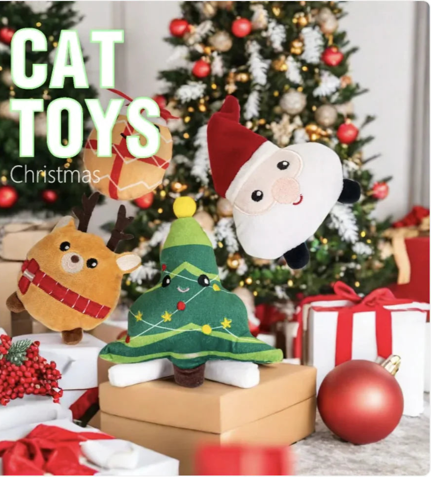 Cat toys with Christmas theme in front of a decorated Christmas tree.
