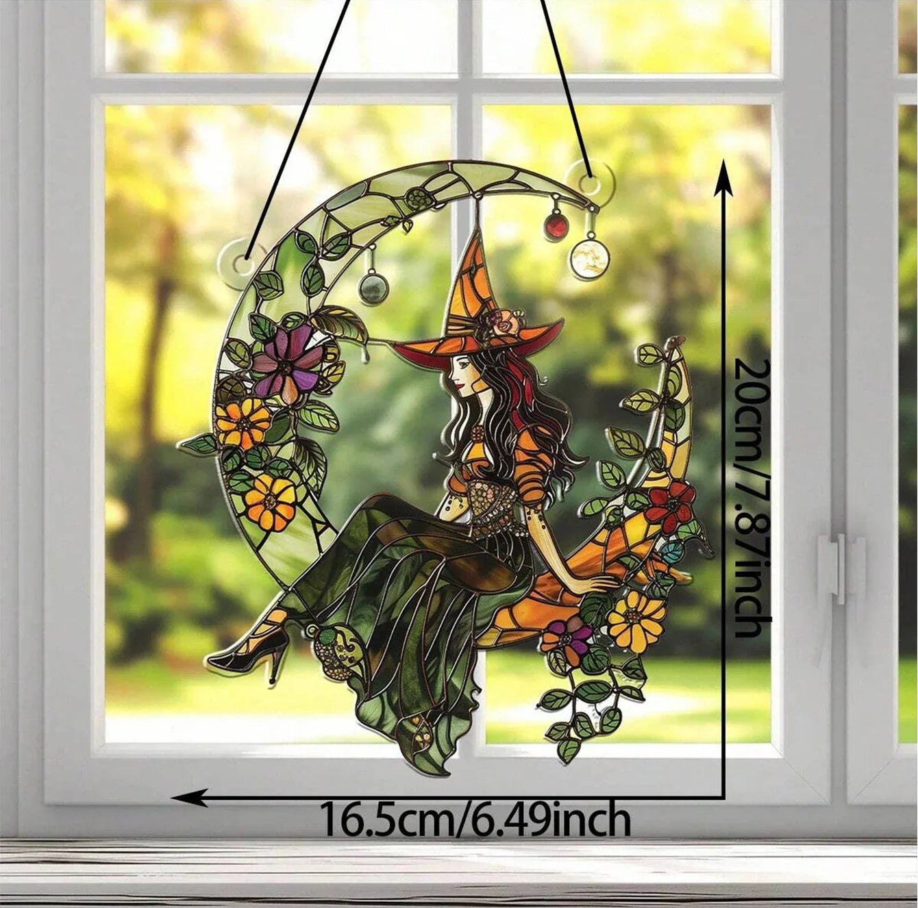 Decorative window hanging with a witch design, made with acrylic, not glass, on a window background.