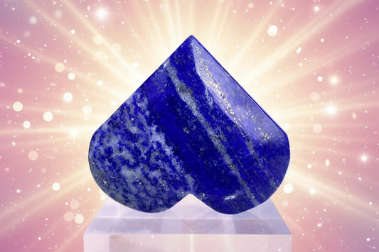 Heart-shaped blue stone on a clear stand with a white background
