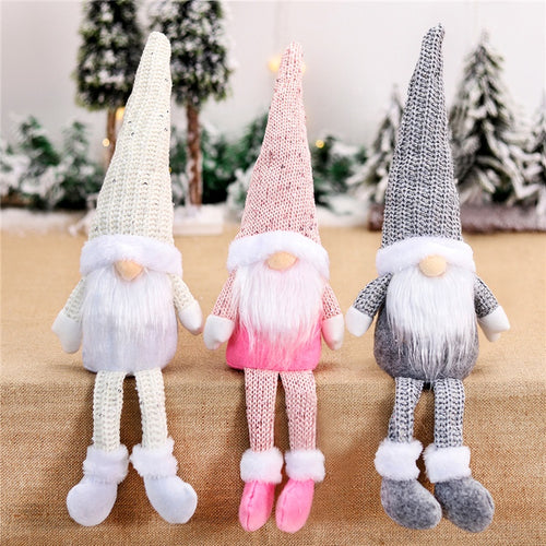 Three knitted gnomes in white, pink, and gray with a snowy background.