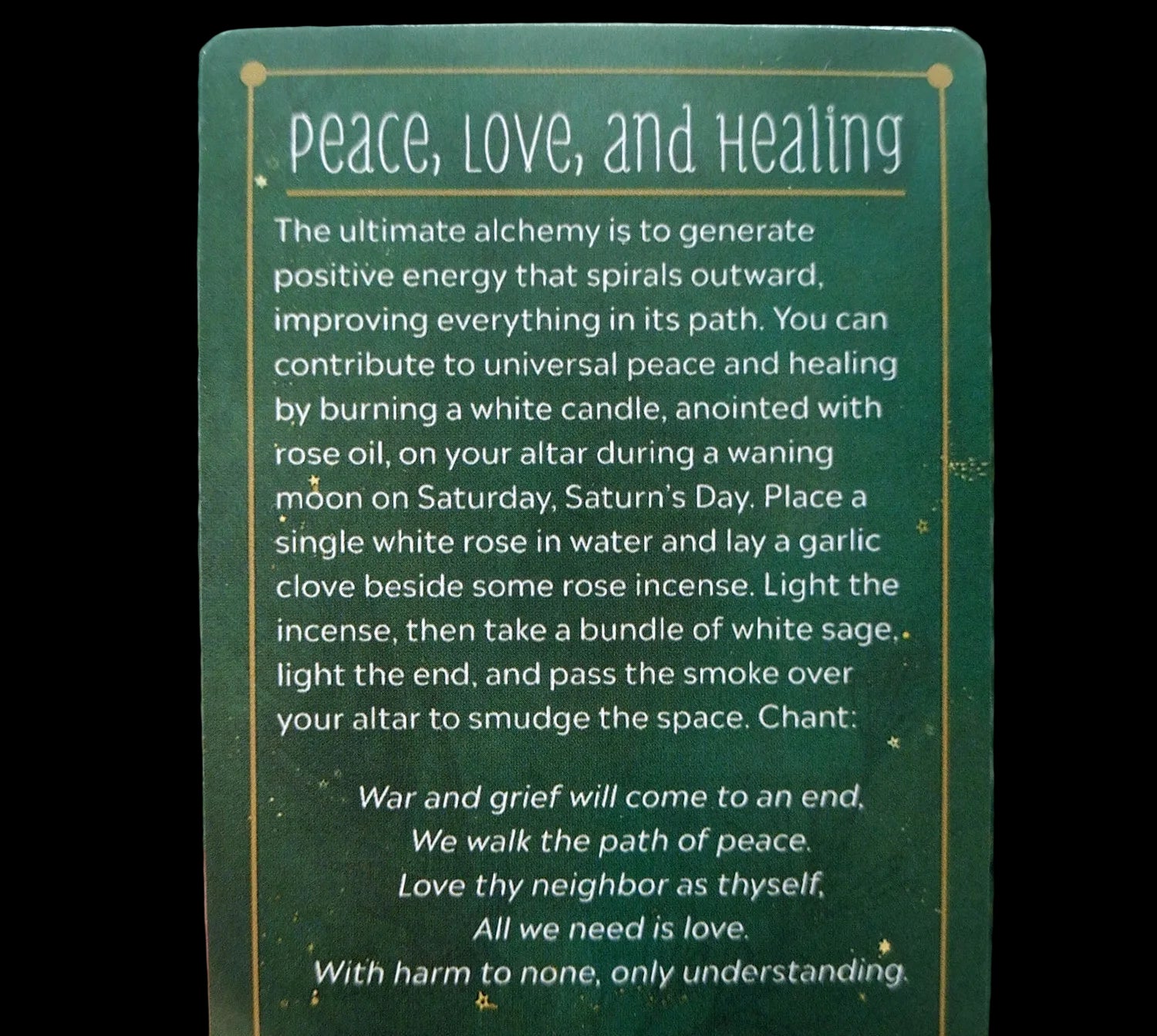 Green card with text on peace, love, and healing rituals held by a hand.