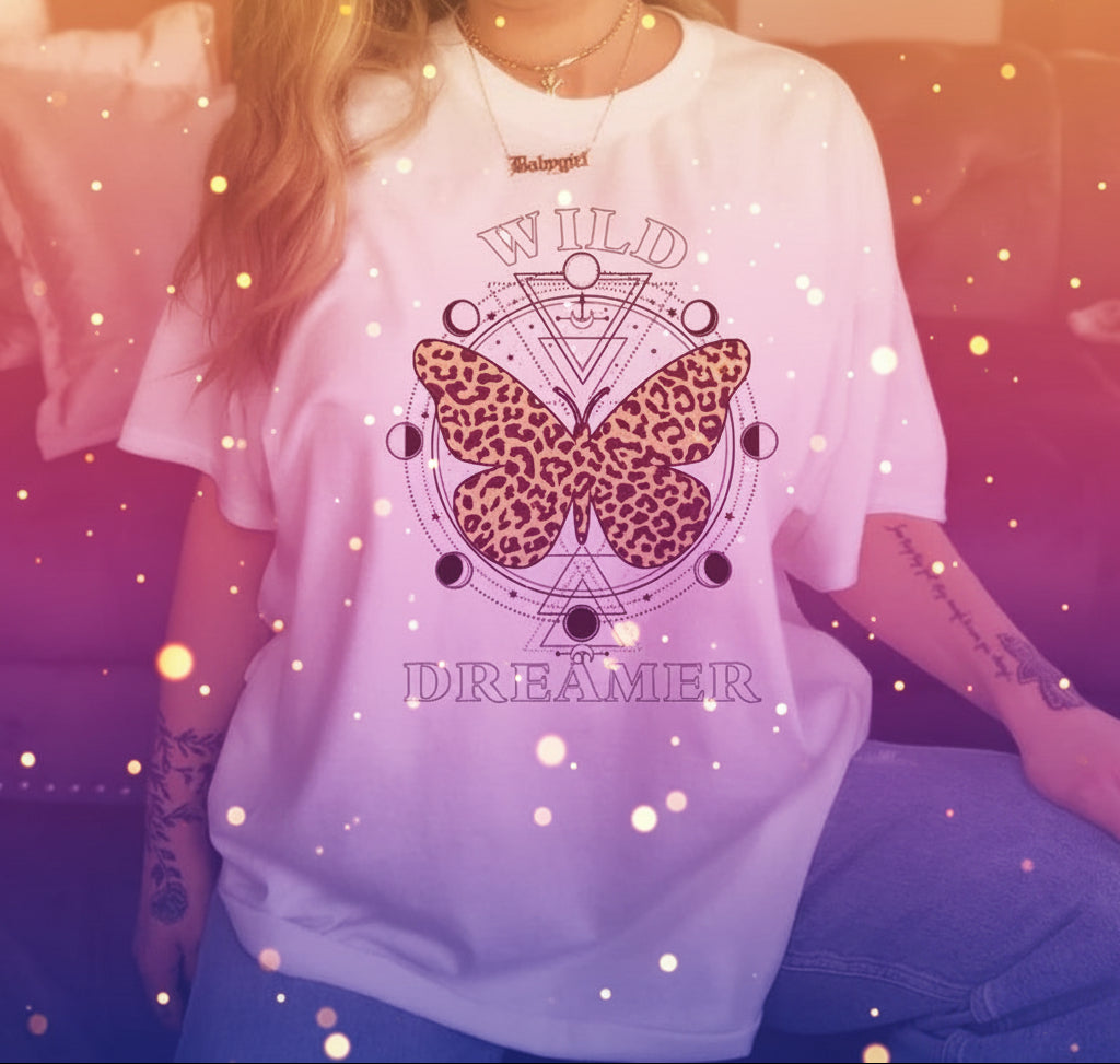 Person wearing a white t-shirt with a leopard print butterfly design and text in a casual setting.