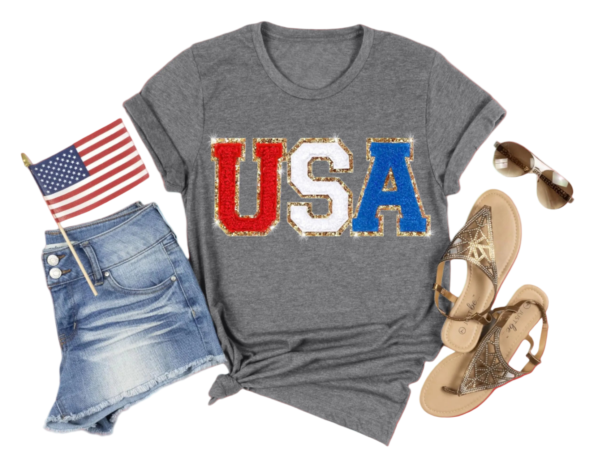 Gray t-shirt with 'USA' print, denim shorts, sandals, and American flag on a white background