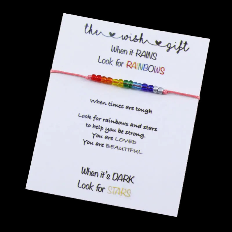 Colorful beaded bracelet on a card with inspirational message on a wooden surface