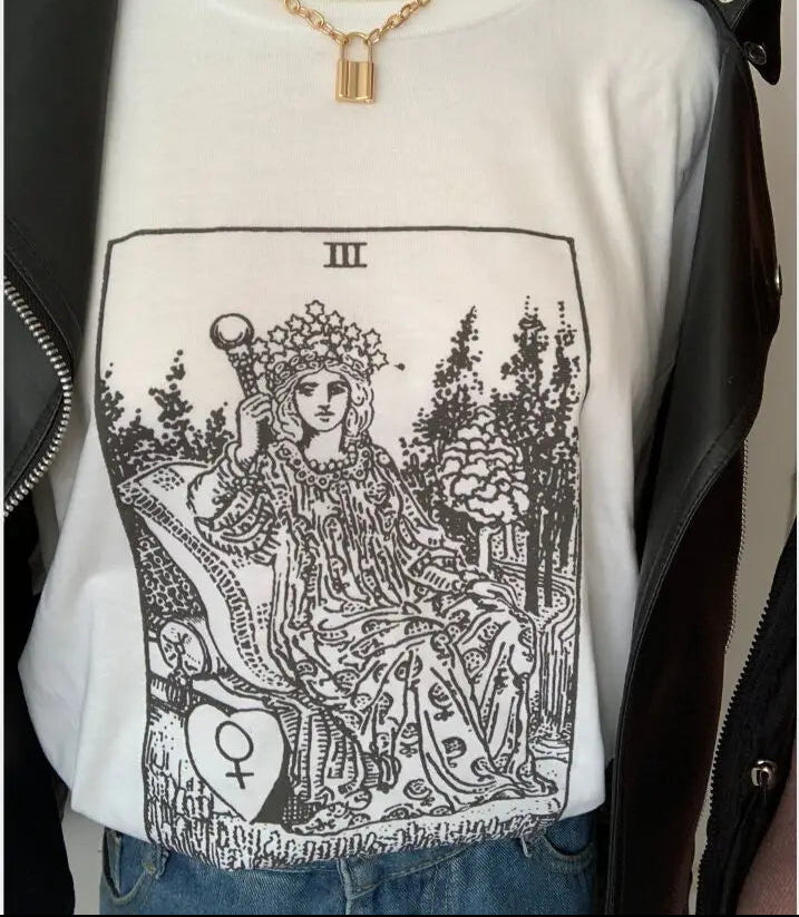 White sweatshirt with tarot card design on a mannequin against a black jacket background