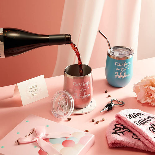 Bottle pouring red liquid into a pink wine tumbler with a blue同行者酒杯 on a pink surface with decorative items.