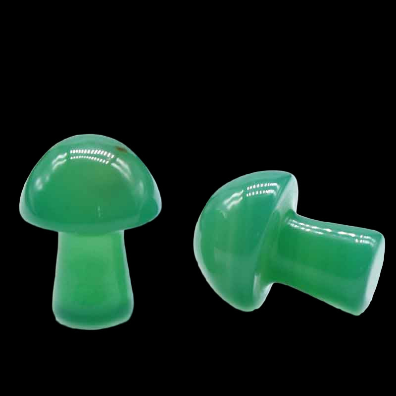 Two green plastic mushroom-shaped objects on a white background