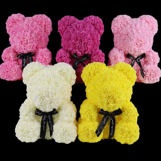 Five teddy bears made of rose petals in pink, white, and yellow with black ribbons on a white background.