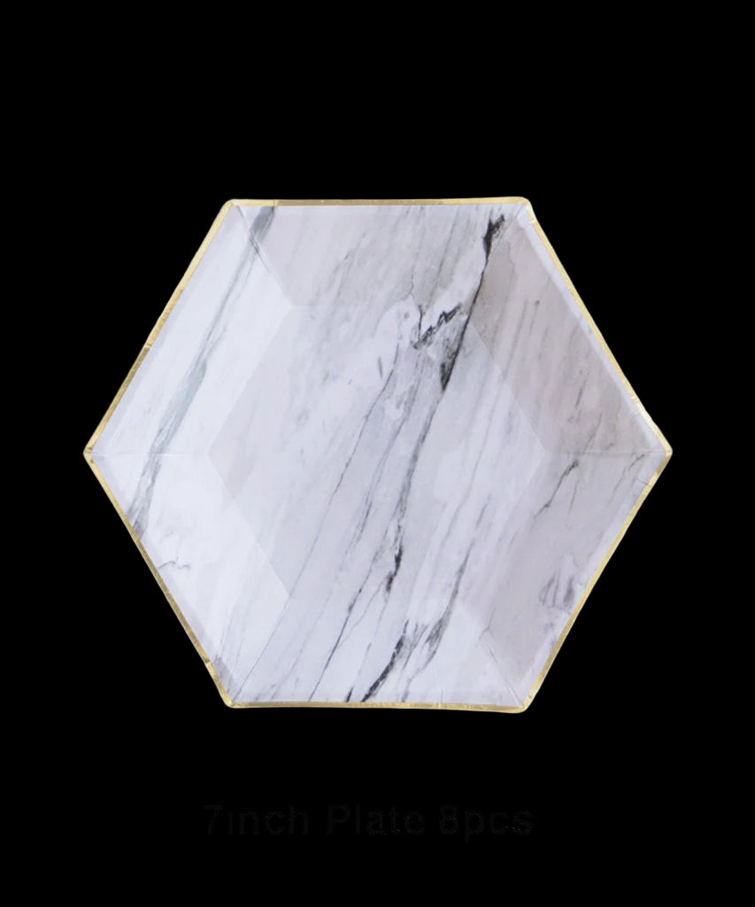 Hexagonal marble-patterned plate with gold rim on a white background
