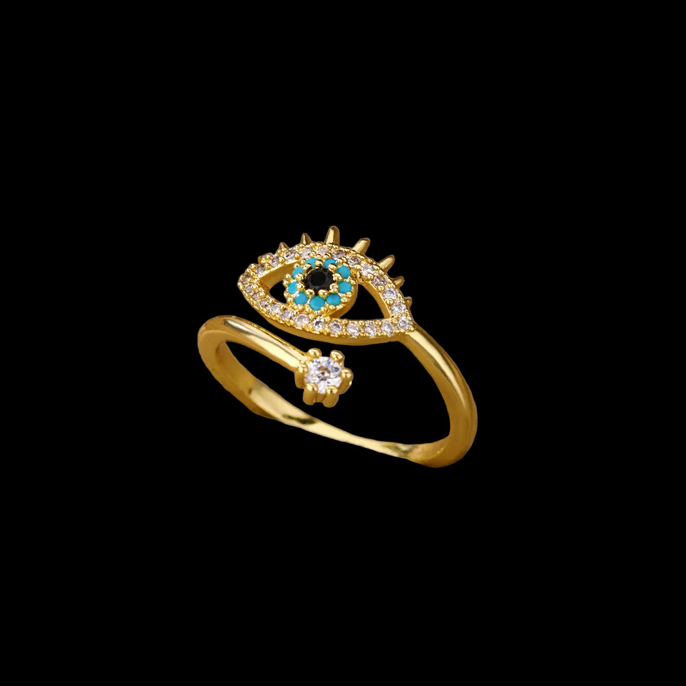 Gold ring with eye design on a beige cushion