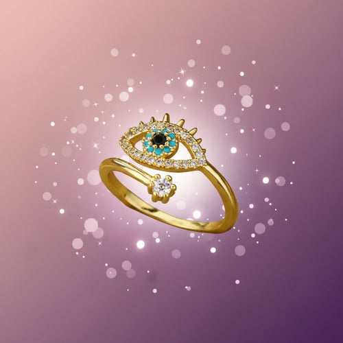Gold ring with eye design on a beige cushion