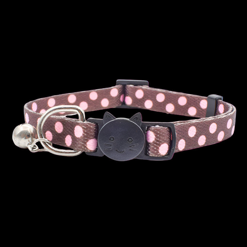 Cat collar with pink polka dots and bell on a white background