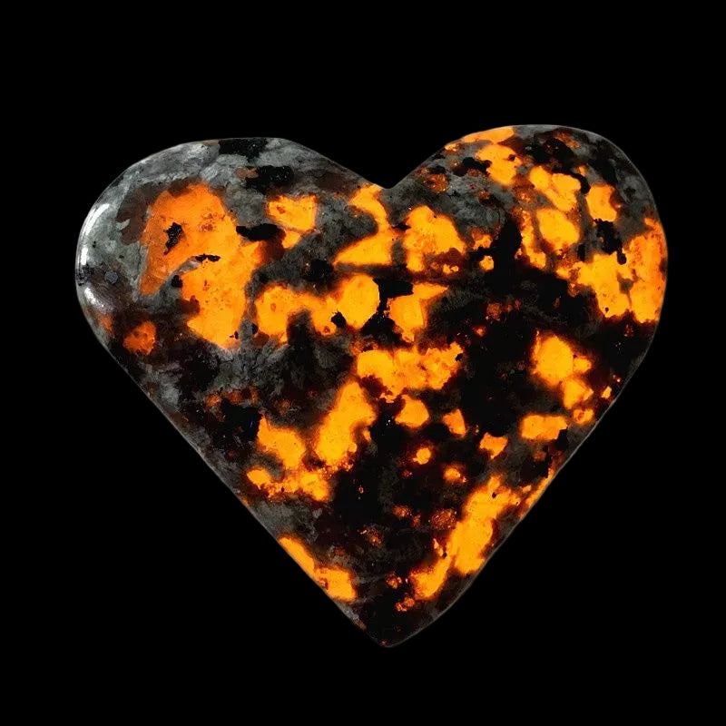 Heart-shaped stone with orange and black pattern on a white background