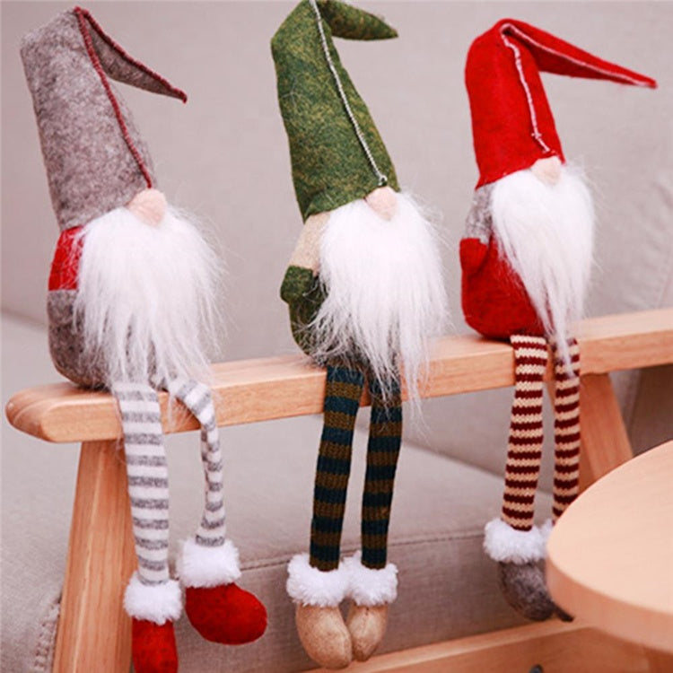 Three festive gnome figurines with striped legs sitting on a wooden stool.