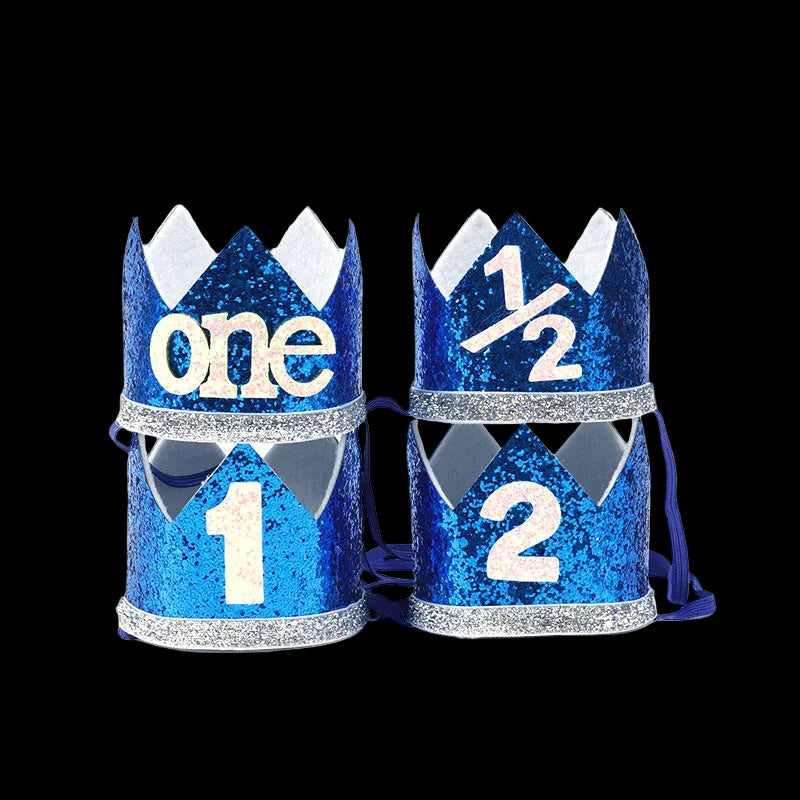 Two blue glitter party hats with numbers '1' and '2' on a white background
