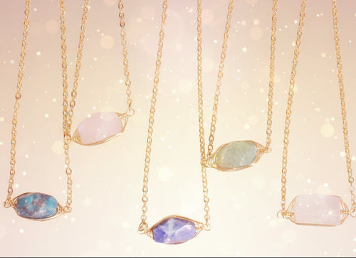 Gold necklaces with various gemstones on a white background