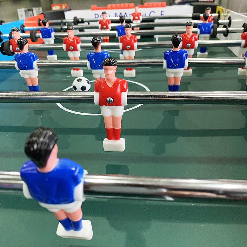 Close-up of a foosball table with players in red and blue uniforms.