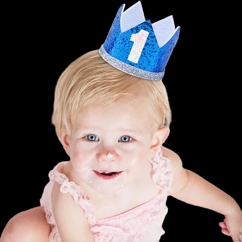 Baby wearing a blue birthday crown with the number 1 on a white background