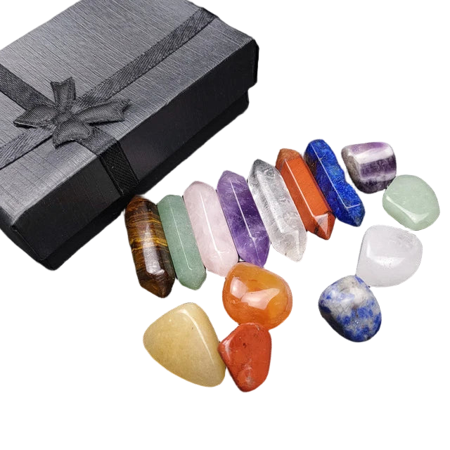Set of colorful crystals on a dark surface with a black gift box.