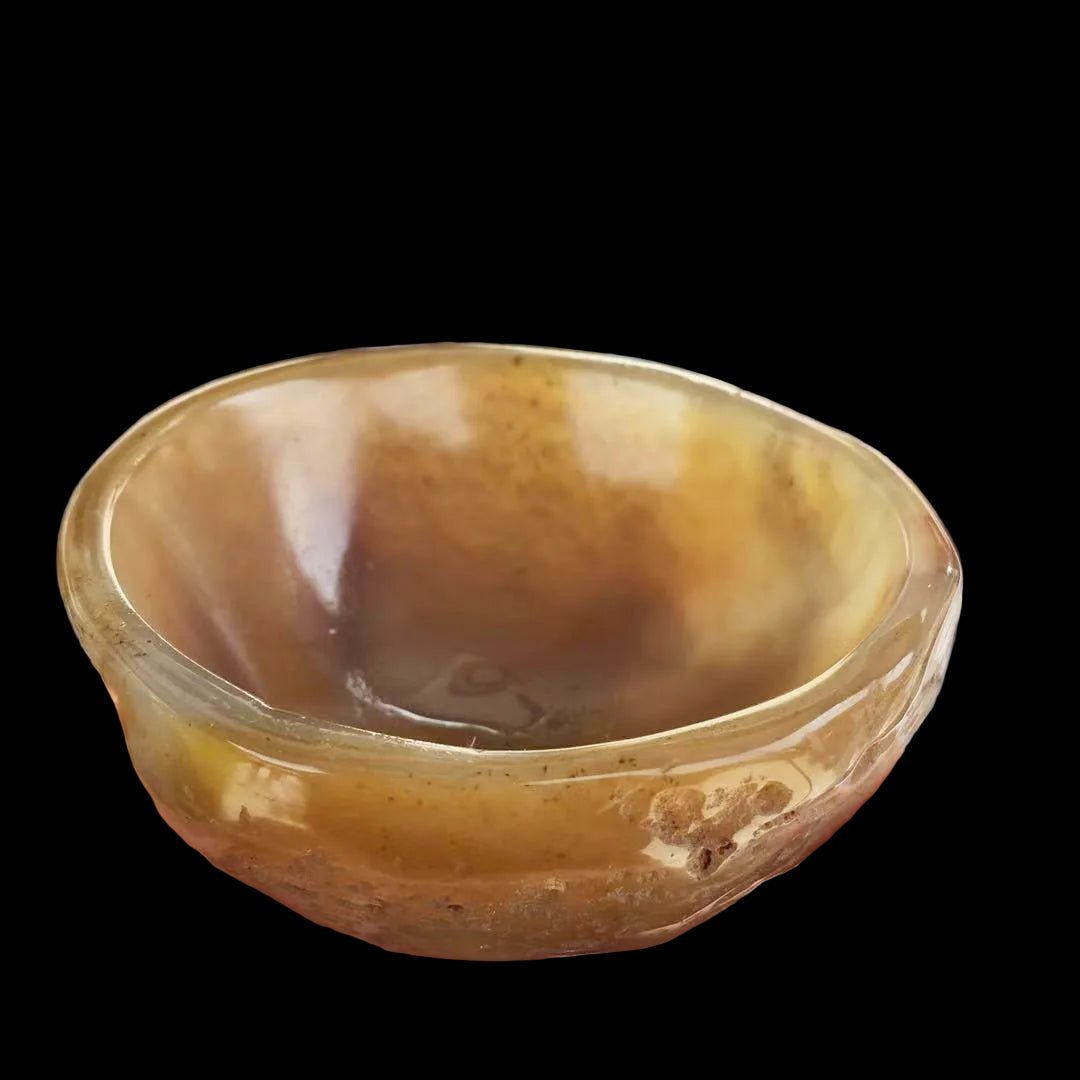 Hand holding a brown agate bowl with more bowls in the background