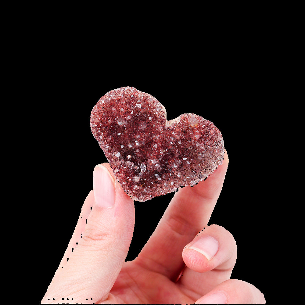 Heart-shaped crystal held between fingers on a white background