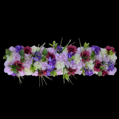 Floral arrangement with purple, green, and pink flowers on a gray background