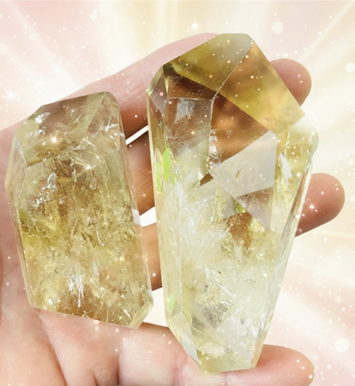 Hand holding two crystal-like stones against a light background