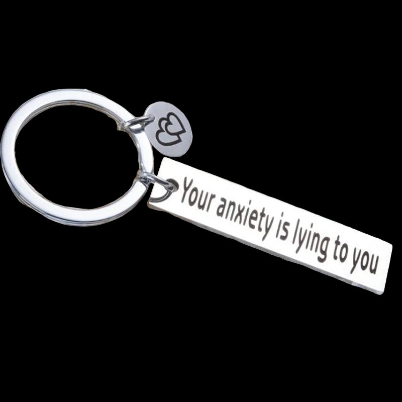 Keychain with motivational message on a white pebble background