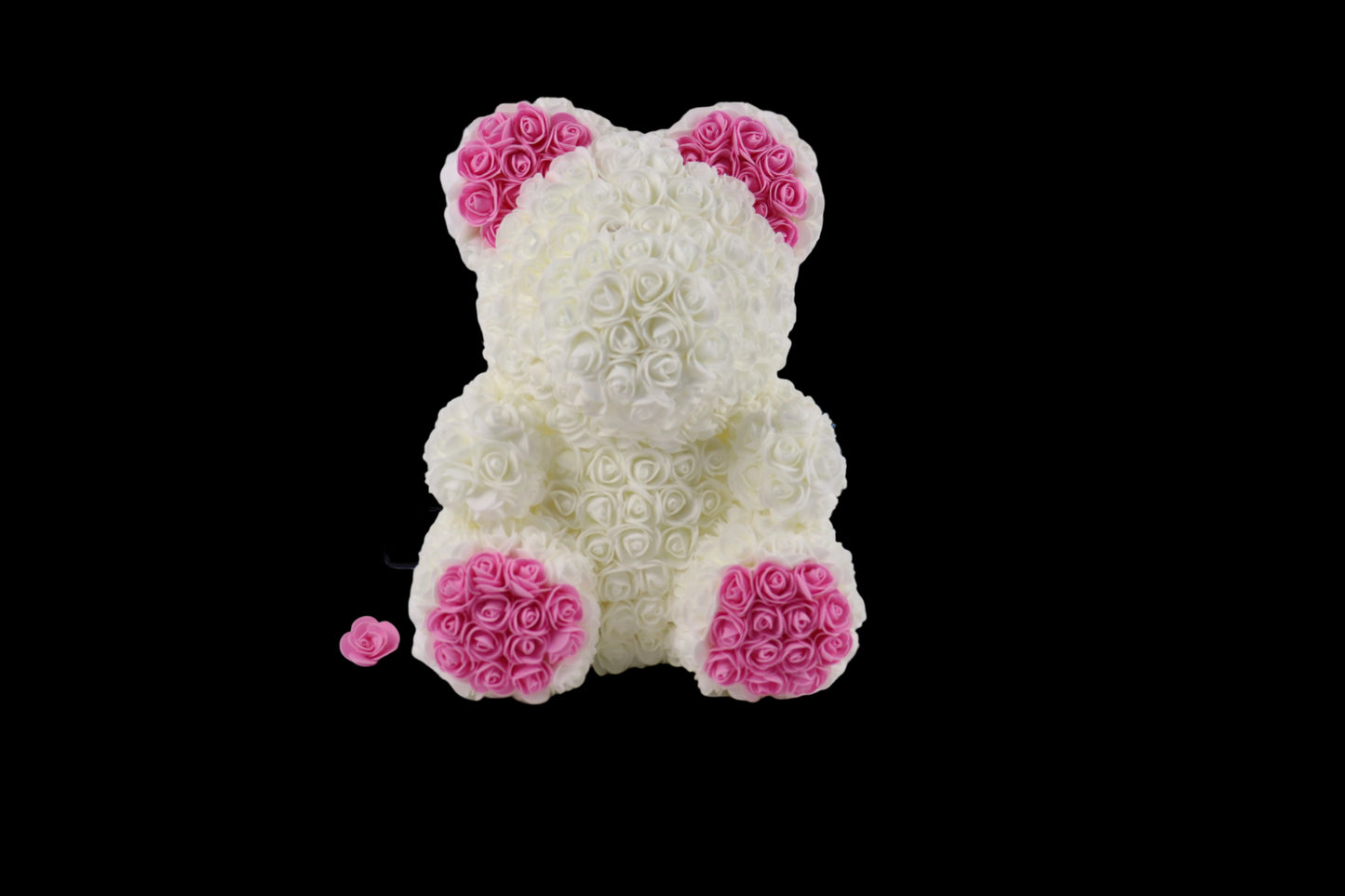 White teddy bear made of rose petals with pink accents on a white background