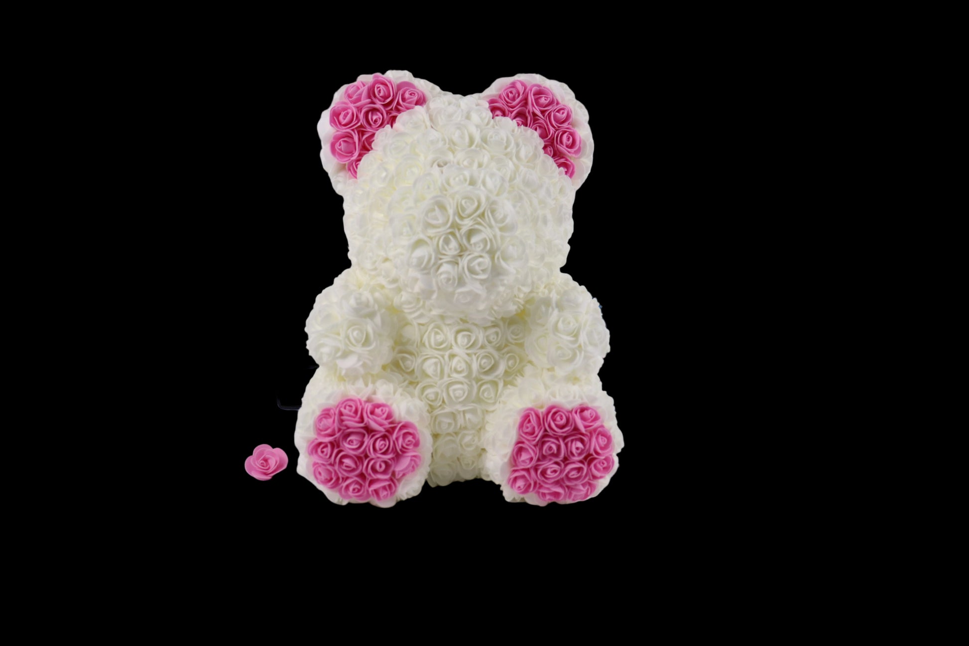 White teddy bear made of rose petals with pink accents on a white background