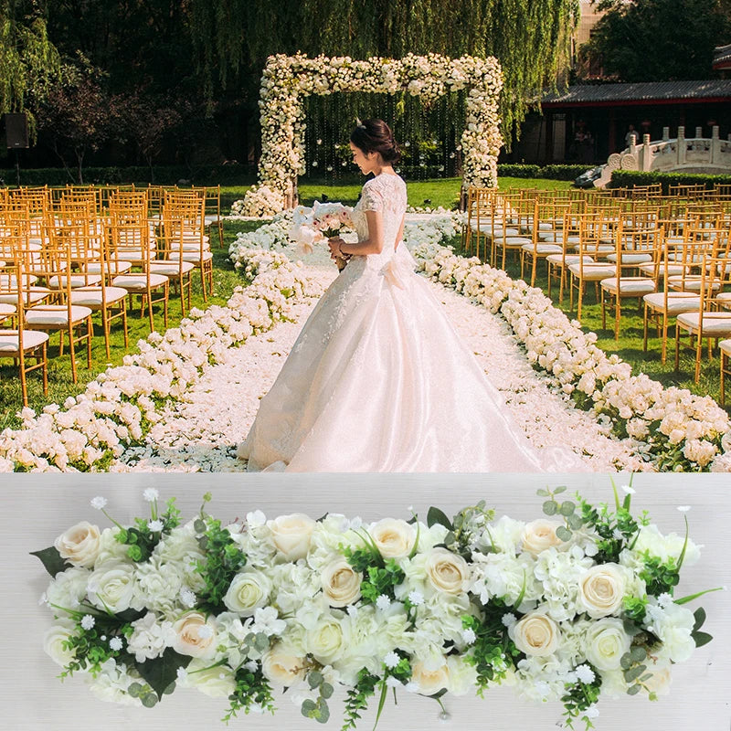 Woman in a wedding dress standing under a floral archway with decorated chairs and flowers on the ground.