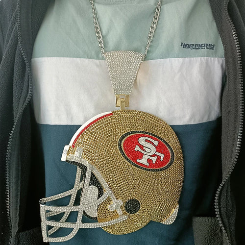 Decorative purse shaped like a football helmet with rhinestones, worn by a person.