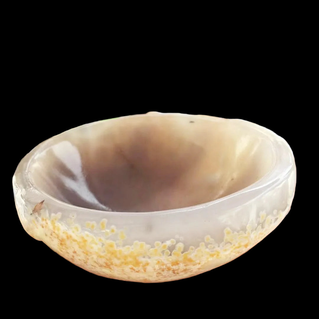 Hand holding a marbled agate bowl with colorful beads in the background