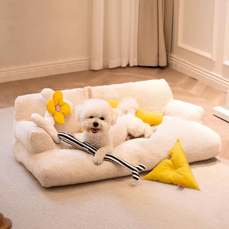 Dog lying on a fluffy pet bed with yellow flower decorations in a room.