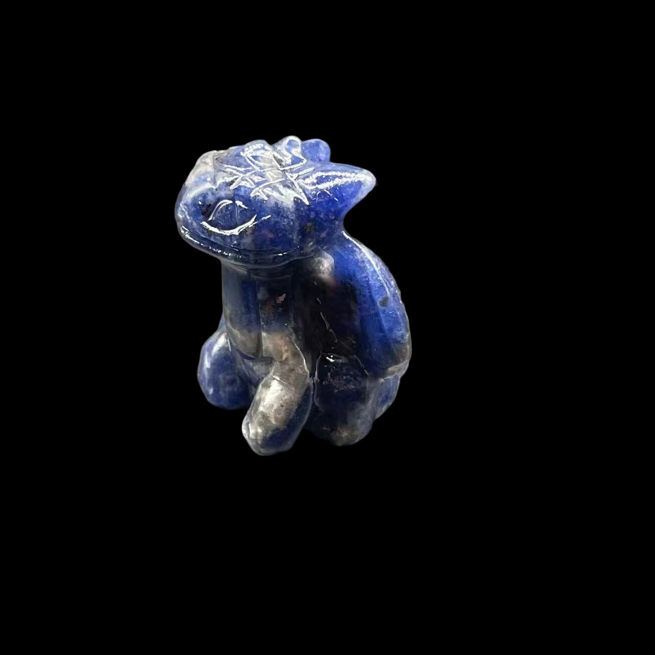 Blue stone figurine of a bear on a gray surface
