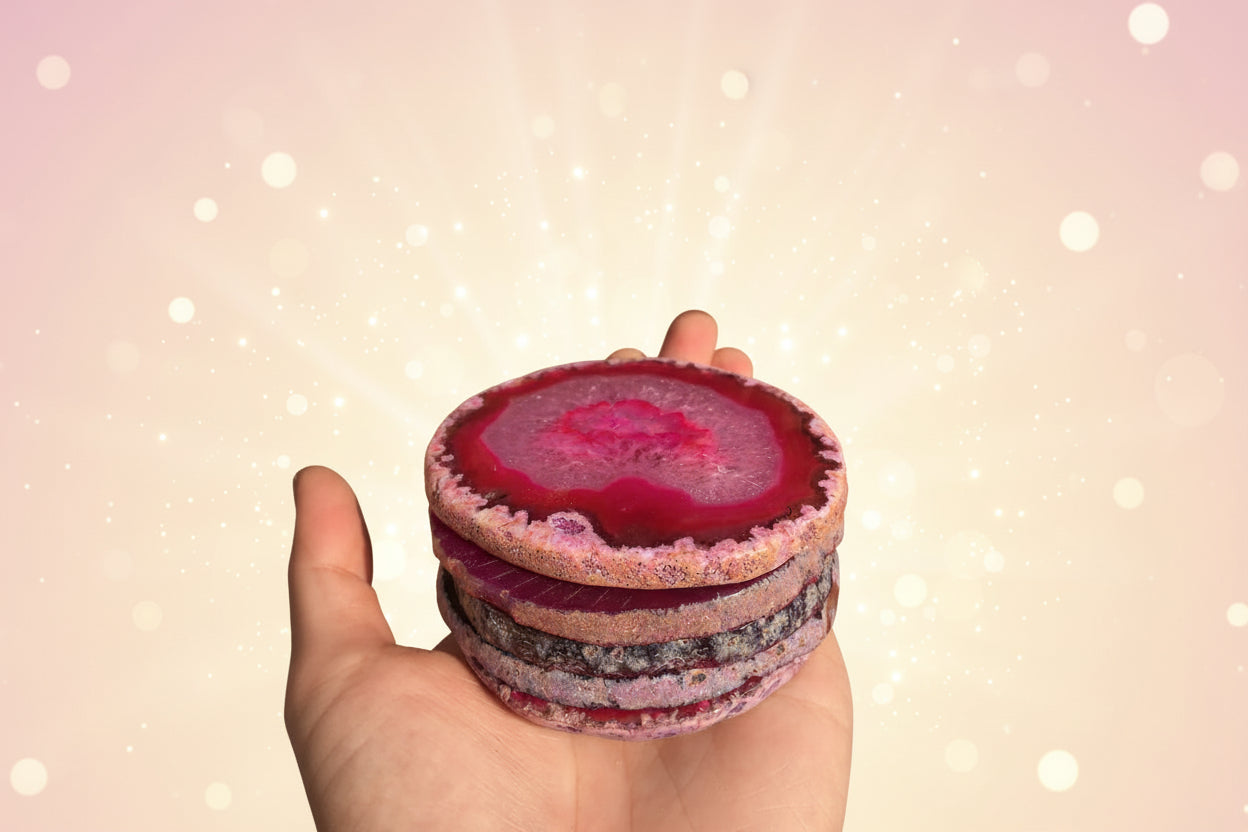 Stack of colorful agate slices held in a hand with a blurred natural background