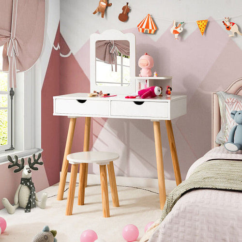 Children's room with a white vanity table, mirror, and stool against a pink wall.