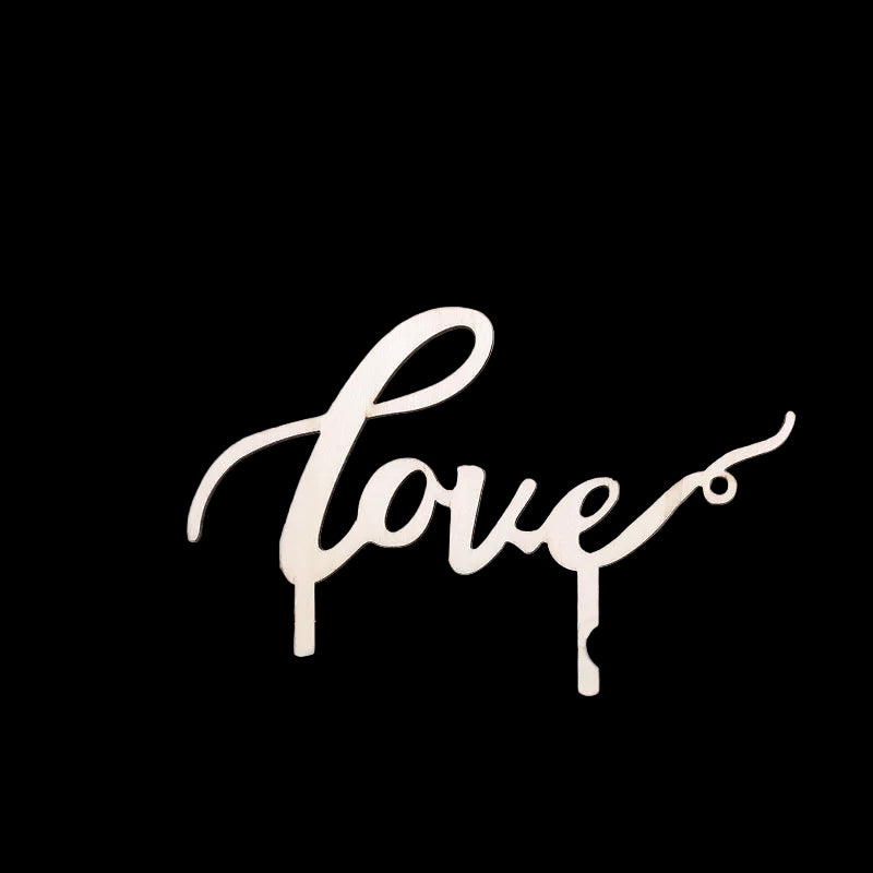 Wooden 'love' sign on a floral cake with a blurred background