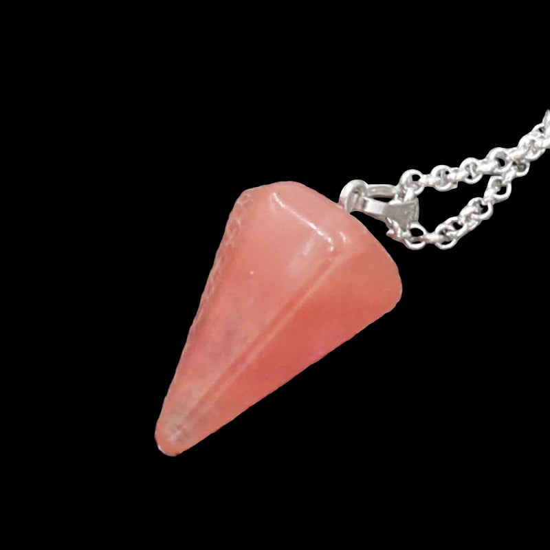 Pink pendant on a chain against a textured silver background