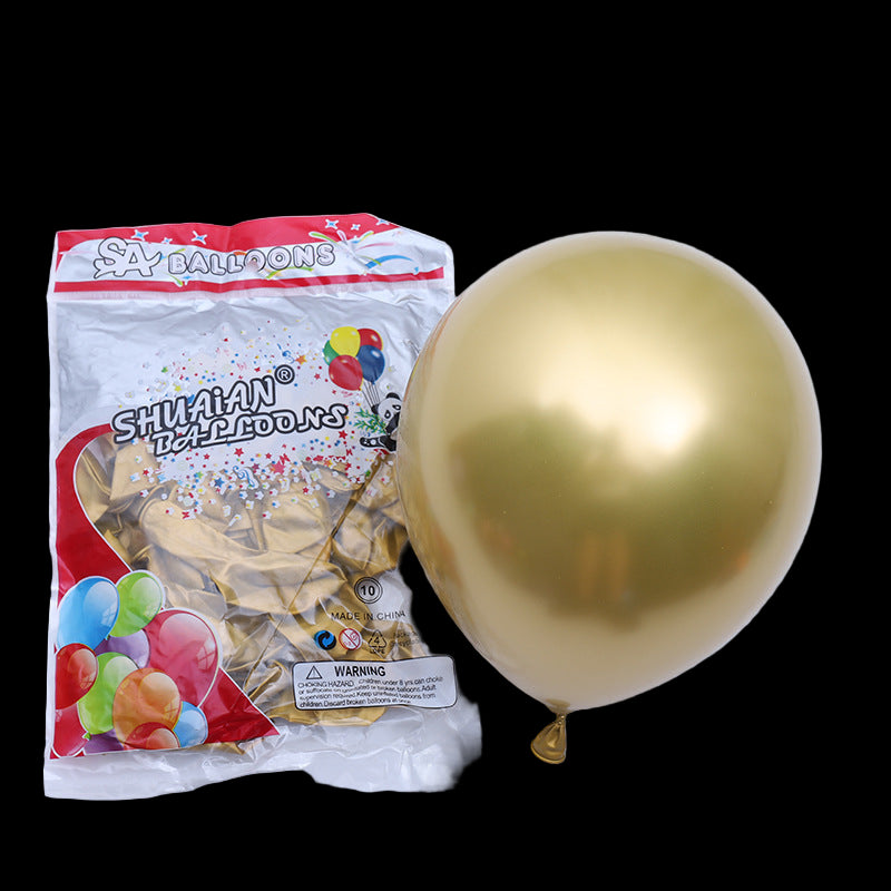 Gold balloon next to its packaging on a white background