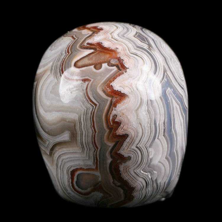Marbled stone with brown, white, and gray patterns on a black background