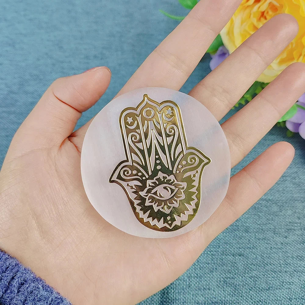 Hand holding a round, transparent stamp with Hamsa design on a blue background